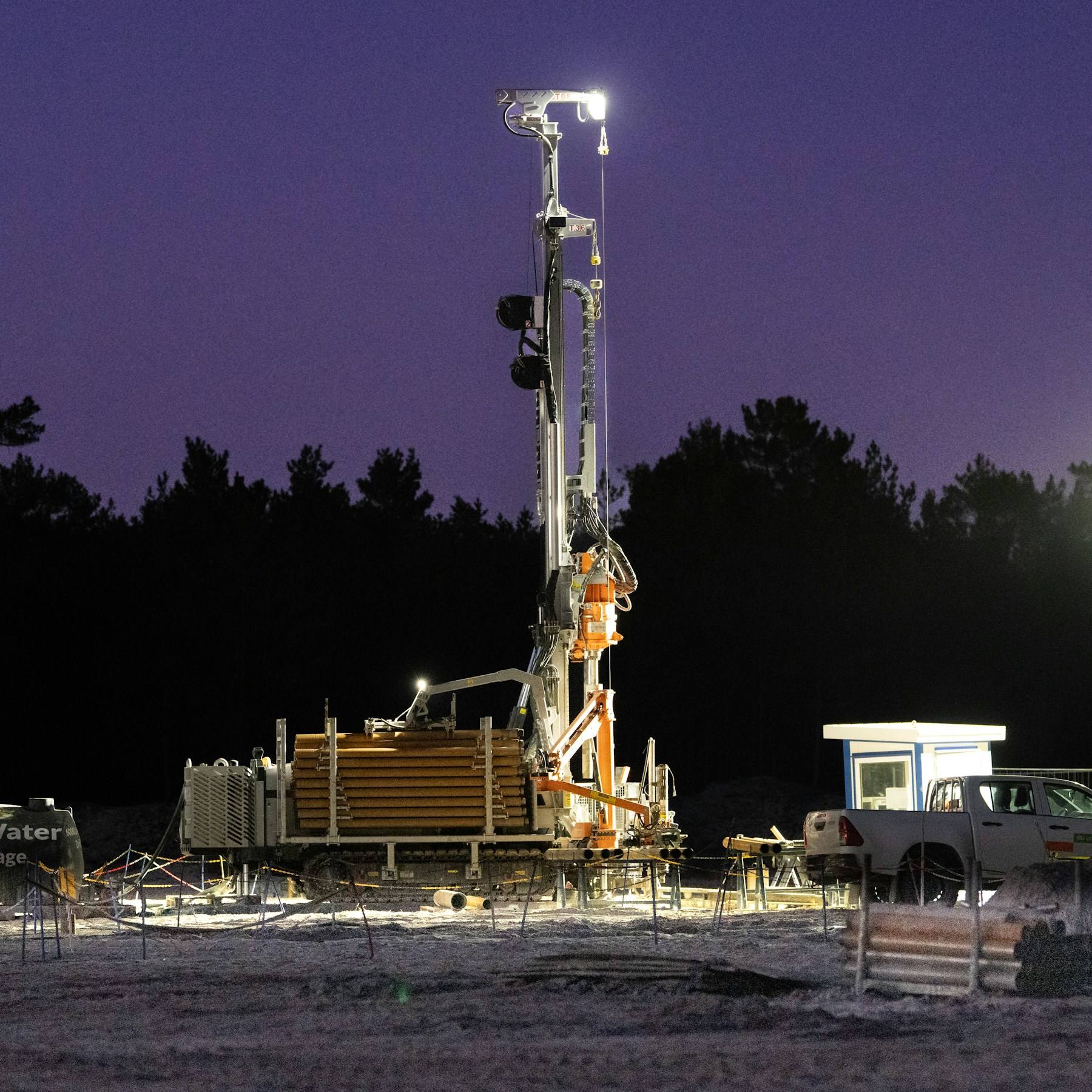 Geotechnical drilling rig working on site at dusk