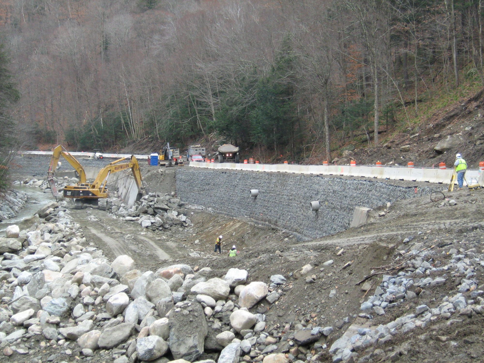 Retaining wall under construction along a river valley road