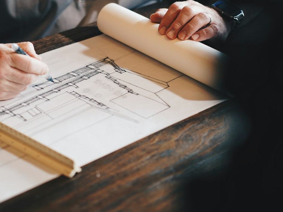 Hands reviewing engineering drawings